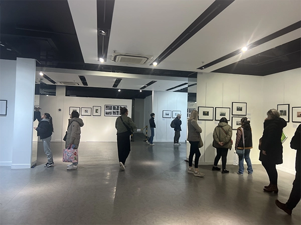 Public audience exploring the photographic narratives during the foundational 2024 Pilot Exhibition.